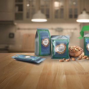 A green and blue Amcor AmPrima recycle-ready stand-up pouch filled with mixed nuts