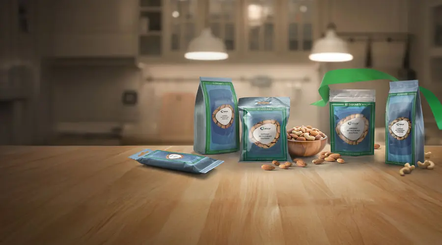 A green and blue Amcor AmPrima recycle-ready stand-up pouch filled with mixed nuts