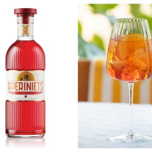 A bottle of red Aperiniets aperitif is on the left, and a glass with orange spritz, ice, and an orange slice on the right.