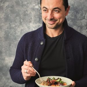 TV Chef Theo Michaels smiling and holding a recipe bowl for the Protein Packed Cans campaign. Image: Canned Food UK