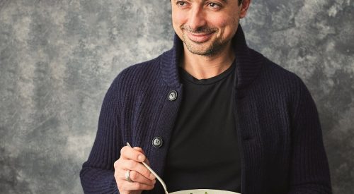 TV Chef Theo Michaels smiling and holding a recipe bowl for the Protein Packed Cans campaign. Image: Canned Food UK