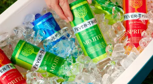 Cans of Fever-Tree beverages (Mojito, Spritz, etc.) sitting in ice in a cooler