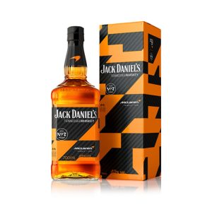 Front view of the 2026 limited edition Jack Daniel's Tennessee Whiskey 700ml bottle and its matching presentation box, featuring the custom McLaren Formula 1 Team black carbon fiber and papaya orange geometric wrap design