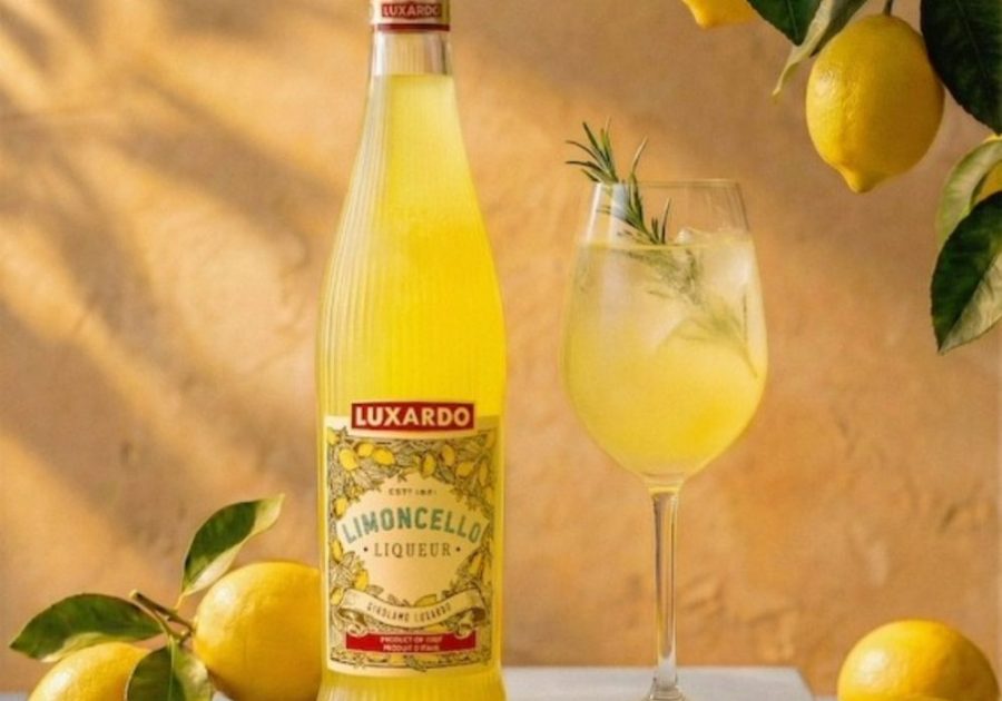 A premium bottle of Luxardo Limoncello showing the new clear glass design with vertical fluting that catches the light, filled with a vibrant yellow lemon liqueur.