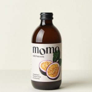 A 330ml glass bottle of MOMO Kombucha Amadora's Passion Fruit.