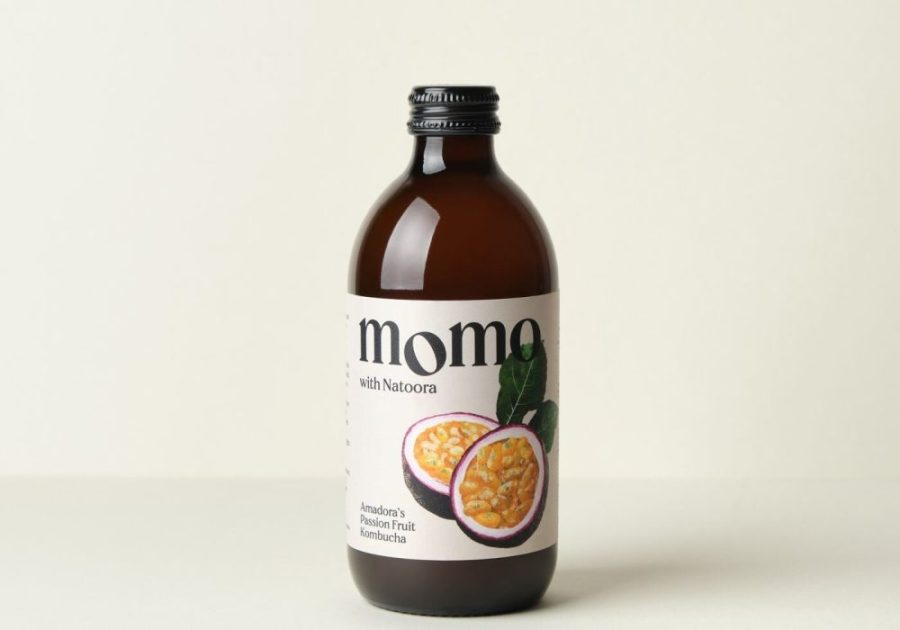 A 330ml glass bottle of MOMO Kombucha Amadora's Passion Fruit.